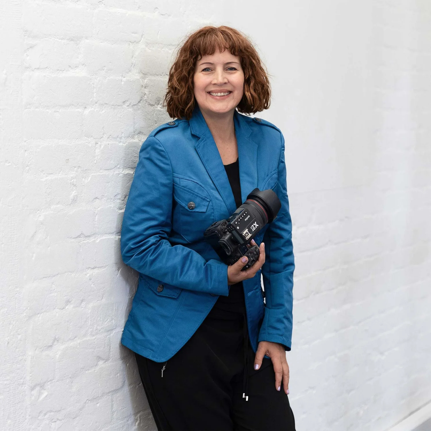 Belinda Bullock, an Auckland headshot and personal branding photographer, holding her camera